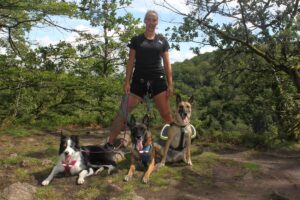 Mia Nilsson fra Team Appetitt Agility på tur i skogen om sommeren med tre av sine hunder.